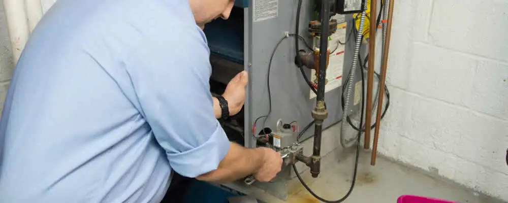 Furnace repair technician inspecting and servicing a home heating system in Overland Park, KS