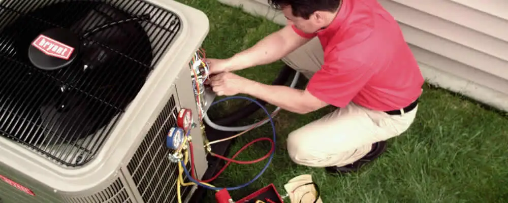 HVAC technician servicing an outdoor air conditioner unit in Overland Park, KS