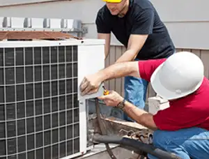 HVAC technicians repairing an outdoor AC unit on a rooftop in Overland Park, KS