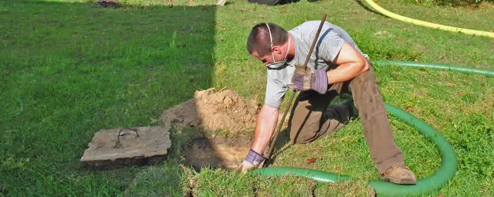 Septic pumping technician servicing a residential septic tank in Overland Park, KS